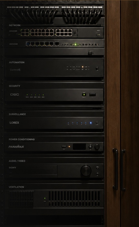 Professionally wired low-voltage equipment rack beside a matching wooden cabinet door